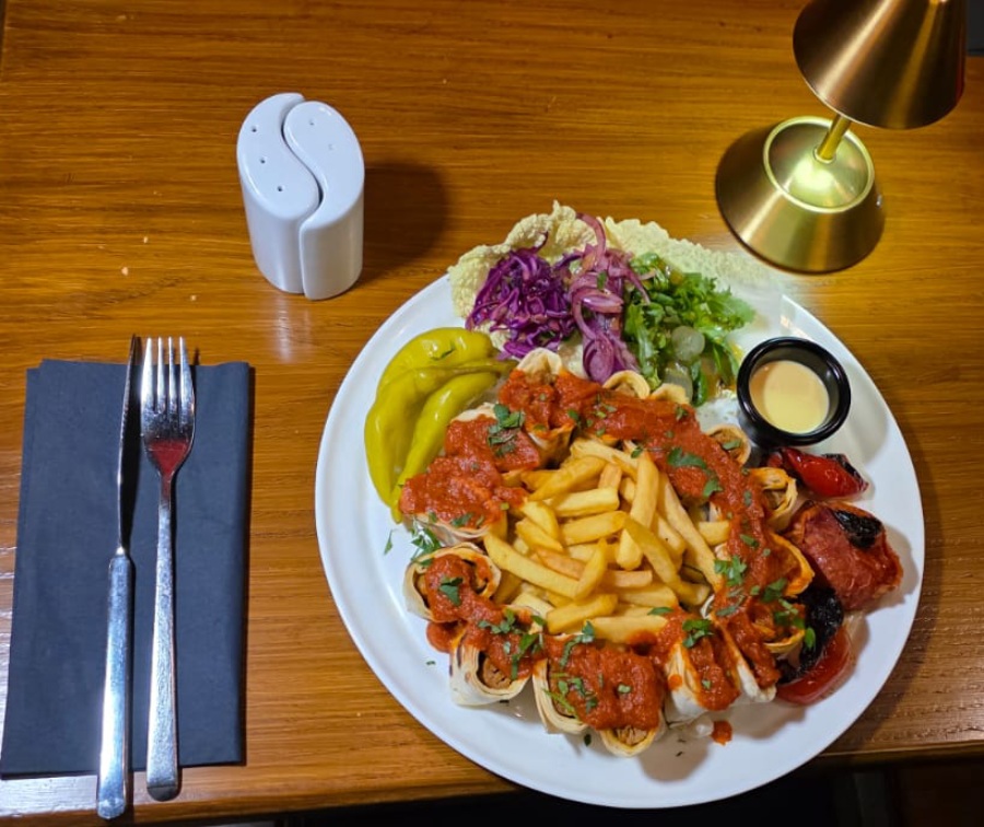 Ziba Restaurant’s plated Persian-style meal featuring wraps topped with tomato sauce, a serving 
of fries in Dunfermline.